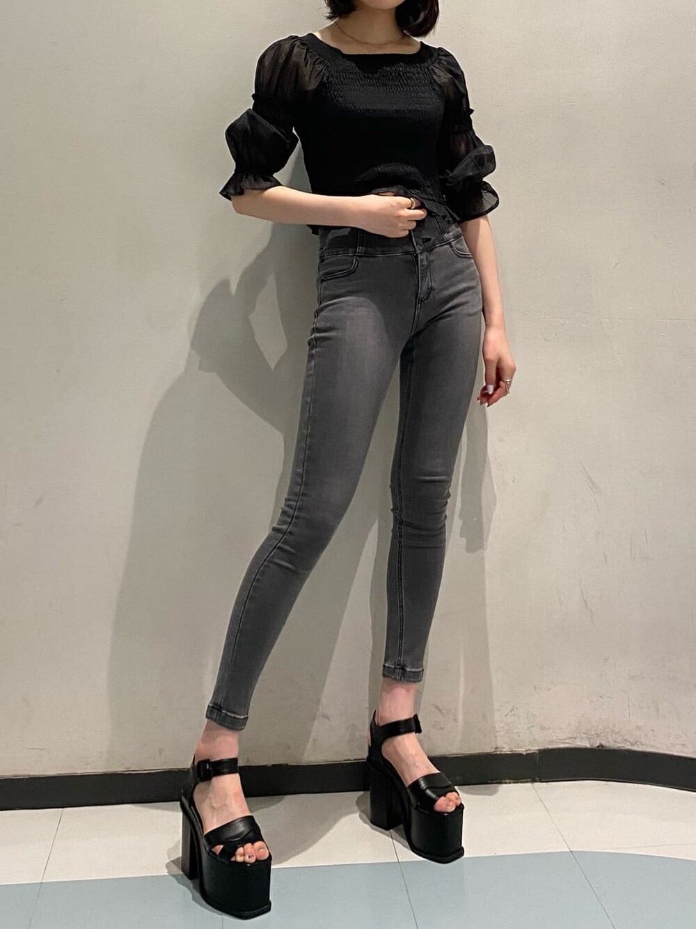 ブラック系のTシャツ/カットソー、グレー系のデニムパンツ、ブラック系のブーツを着用したレディースの夏コーディネートの2枚目の写真