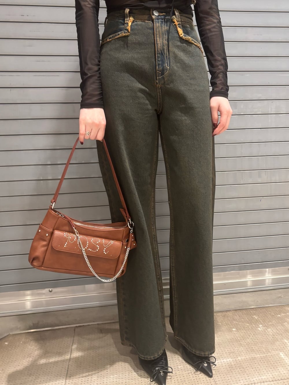 ブルー系のデニムパンツ、ブラウン系のハンドバッグ、ブルー系のタンクトップを着用したレディースの春コーディネートの5枚目の写真