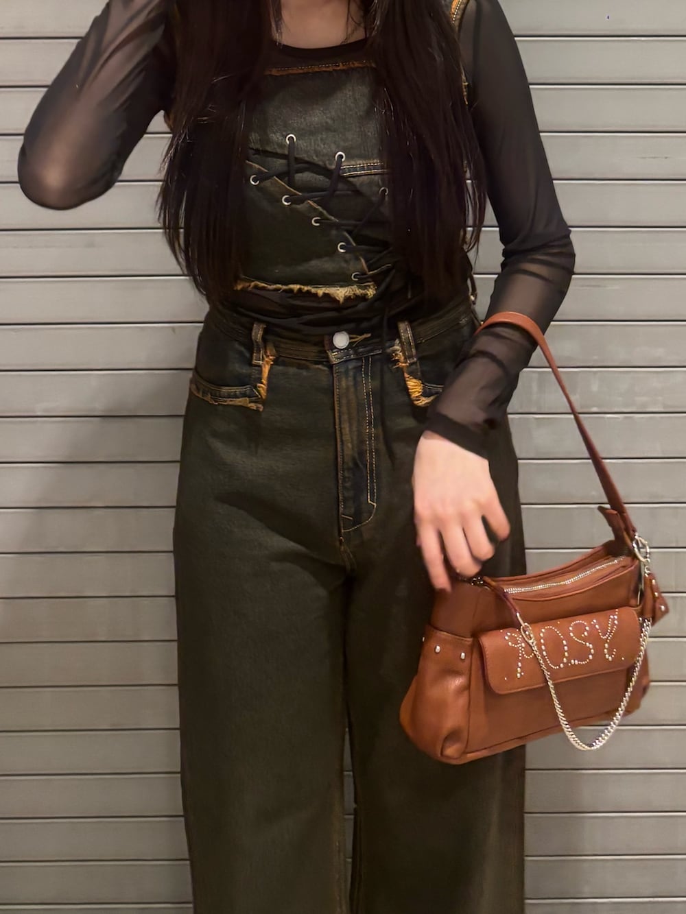 ブルー系のデニムパンツ、ブラウン系のハンドバッグ、ブルー系のタンクトップを着用したレディースの春コーディネートの4枚目の写真