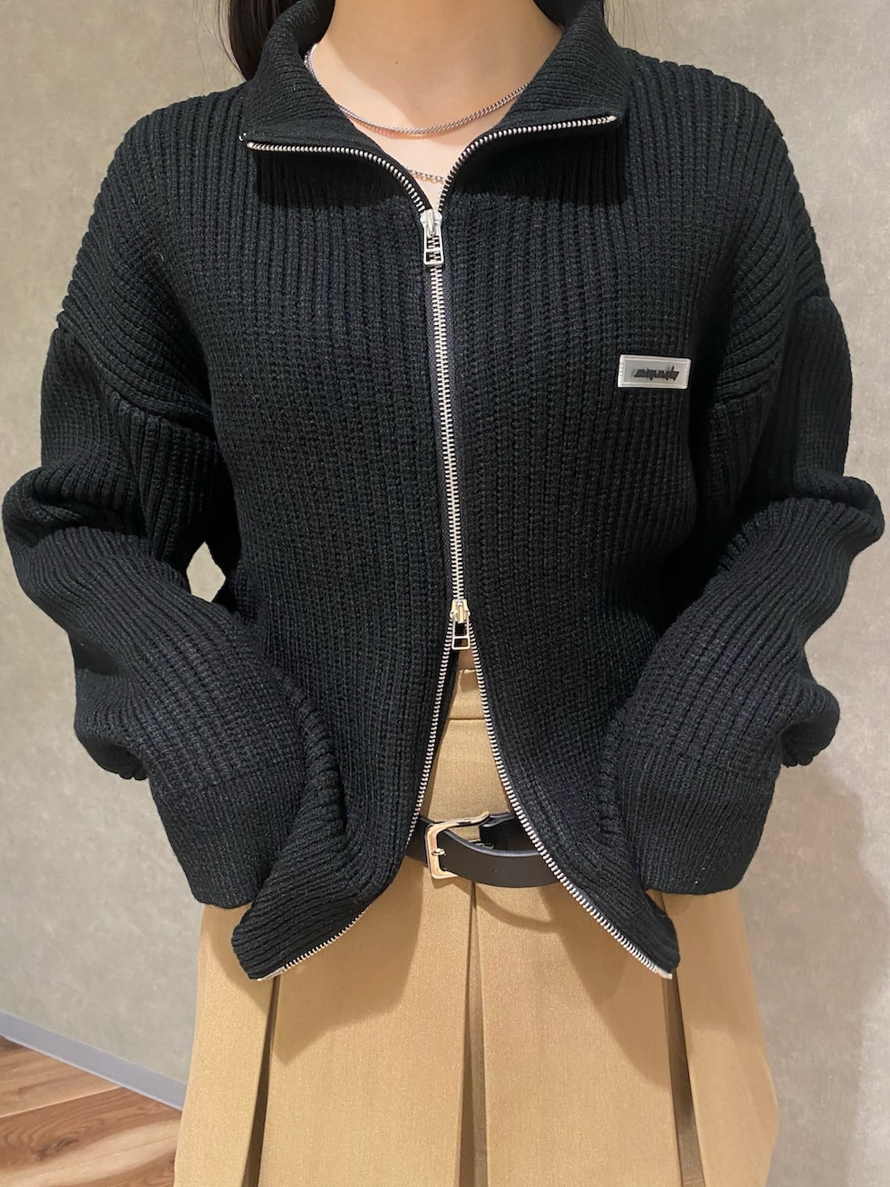 ブラウン系のブーツ、ベージュ系のスカート、ブラック系のニット/セーターを着用したレディースの冬コーディネートの4枚目の写真
