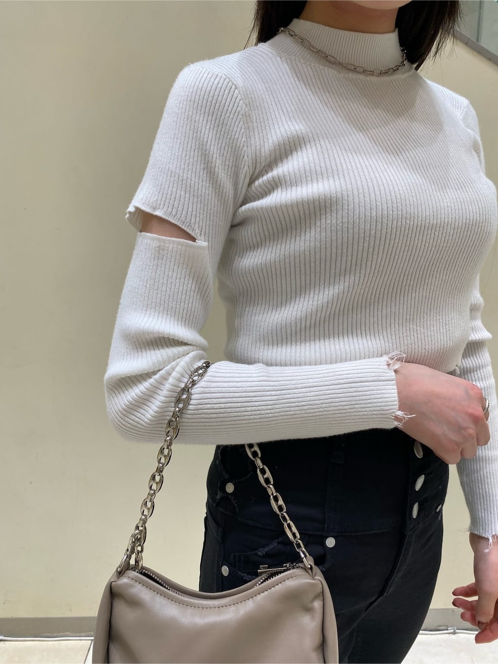 ベージュ系のハンドバッグ、ホワイト系のニット/セーター、ブラック系のデニムパンツを着用したレディースの秋コーディネートの4枚目の写真