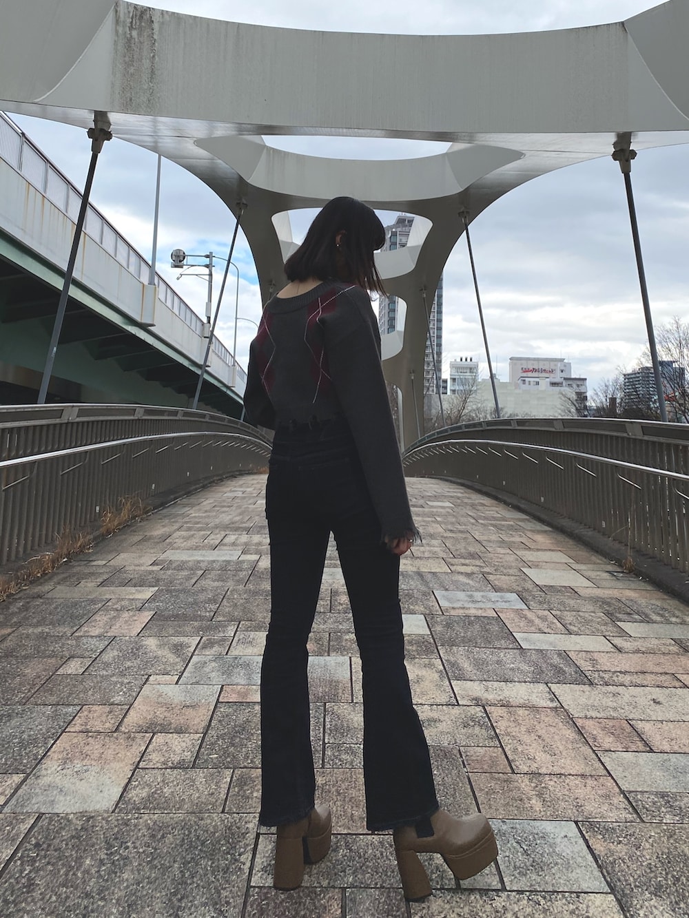 ブラック系のデニムパンツ、その他のニット/セーター、ブラック系のブーツを着用したレディースの冬コーディネートの2枚目の写真