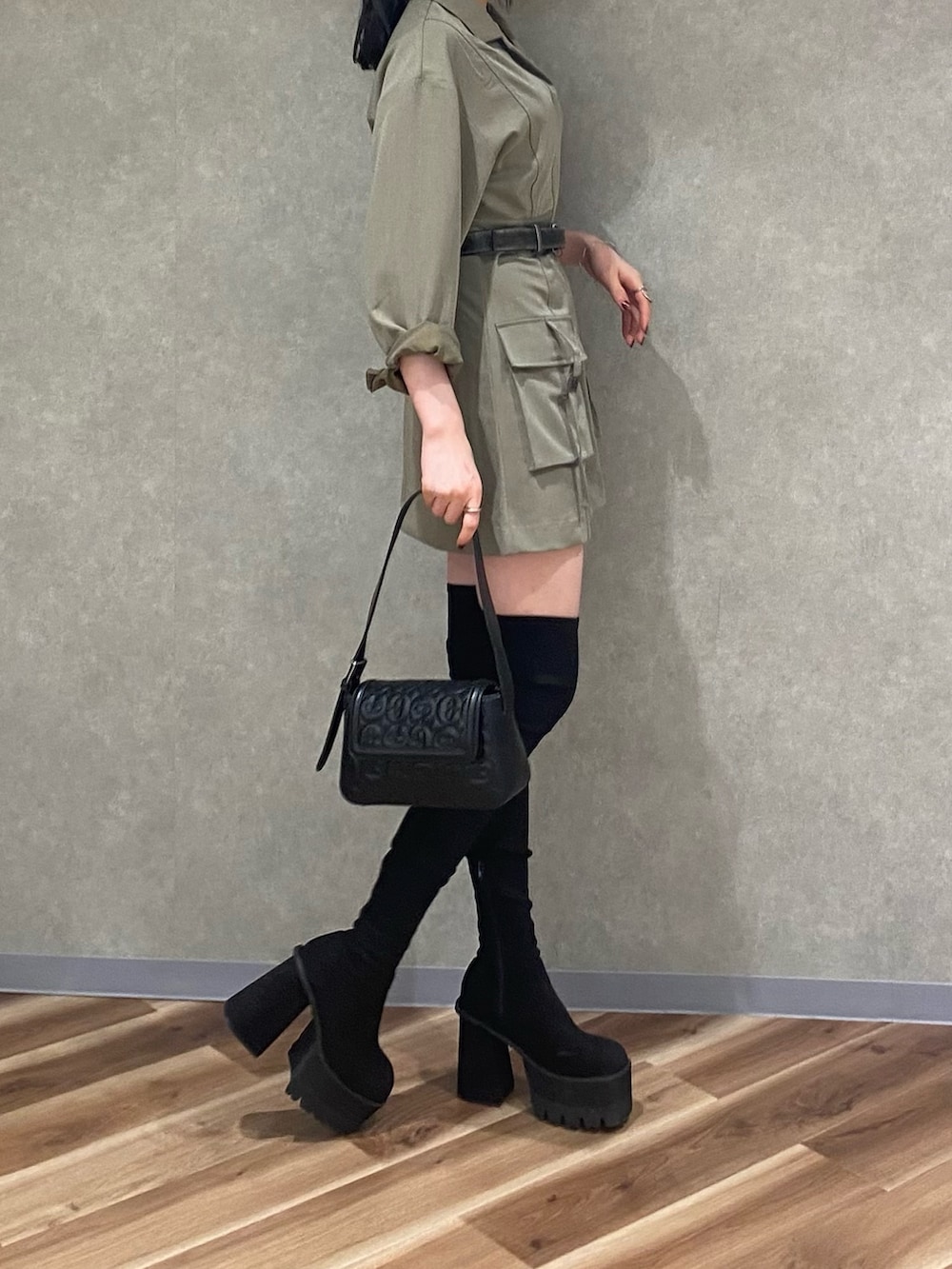 ブラック系のブーツ、ブラック系のハンドバッグ、ベージュ系のワンピースを着用したレディースの秋コーディネートの2枚目の写真