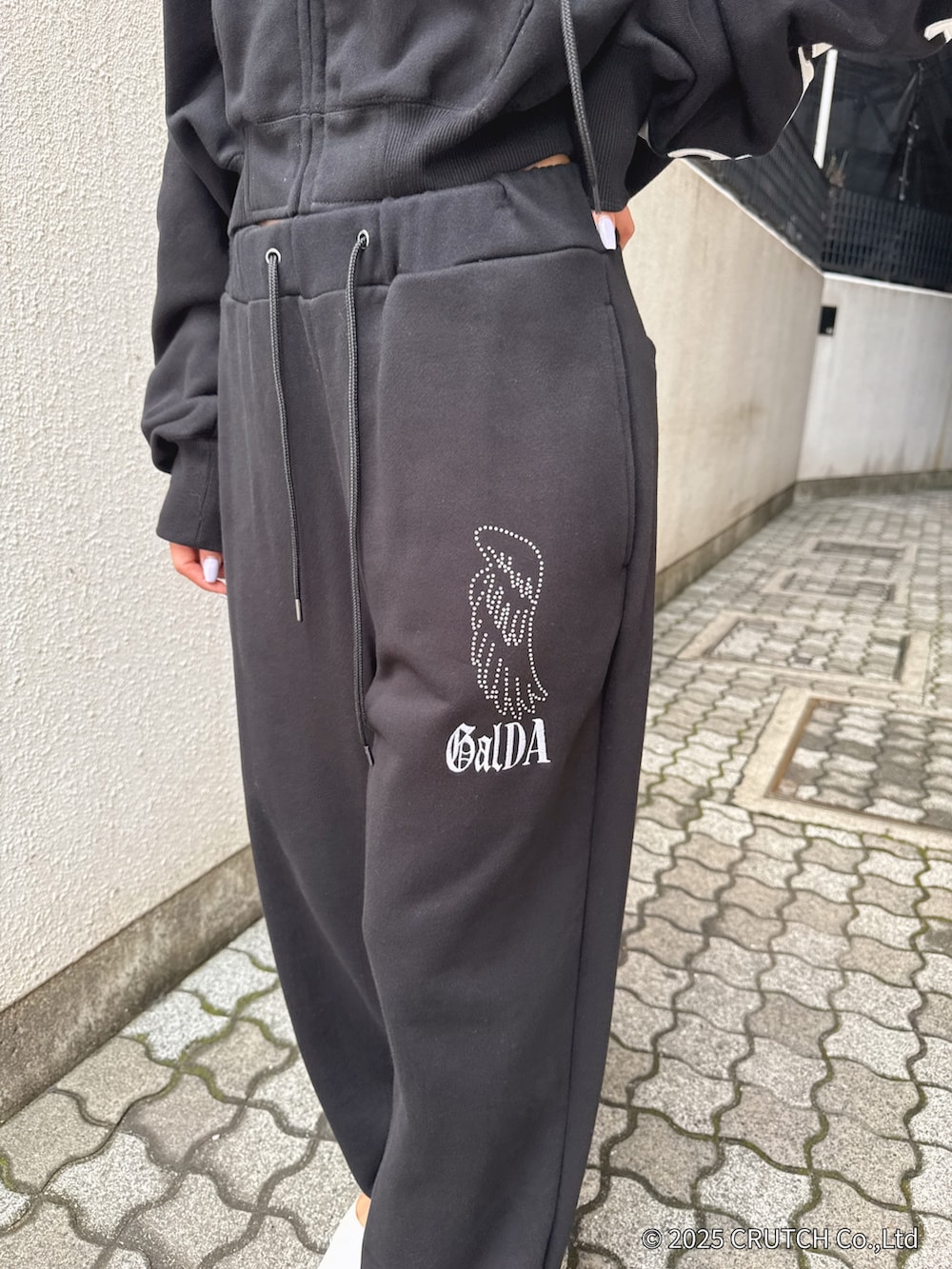 ブラック系のパーカー、ブラック系のその他パンツ、ホワイト系のパンプスを着用したレディースの秋コーディネートの9枚目の写真