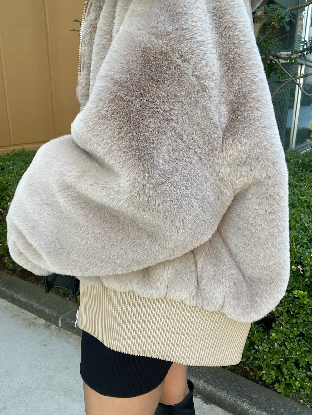 ベージュ系のブルゾン、ブラック系のワンピース、ブラック系のブーツを着用したレディースの冬コーディネートの8枚目の写真