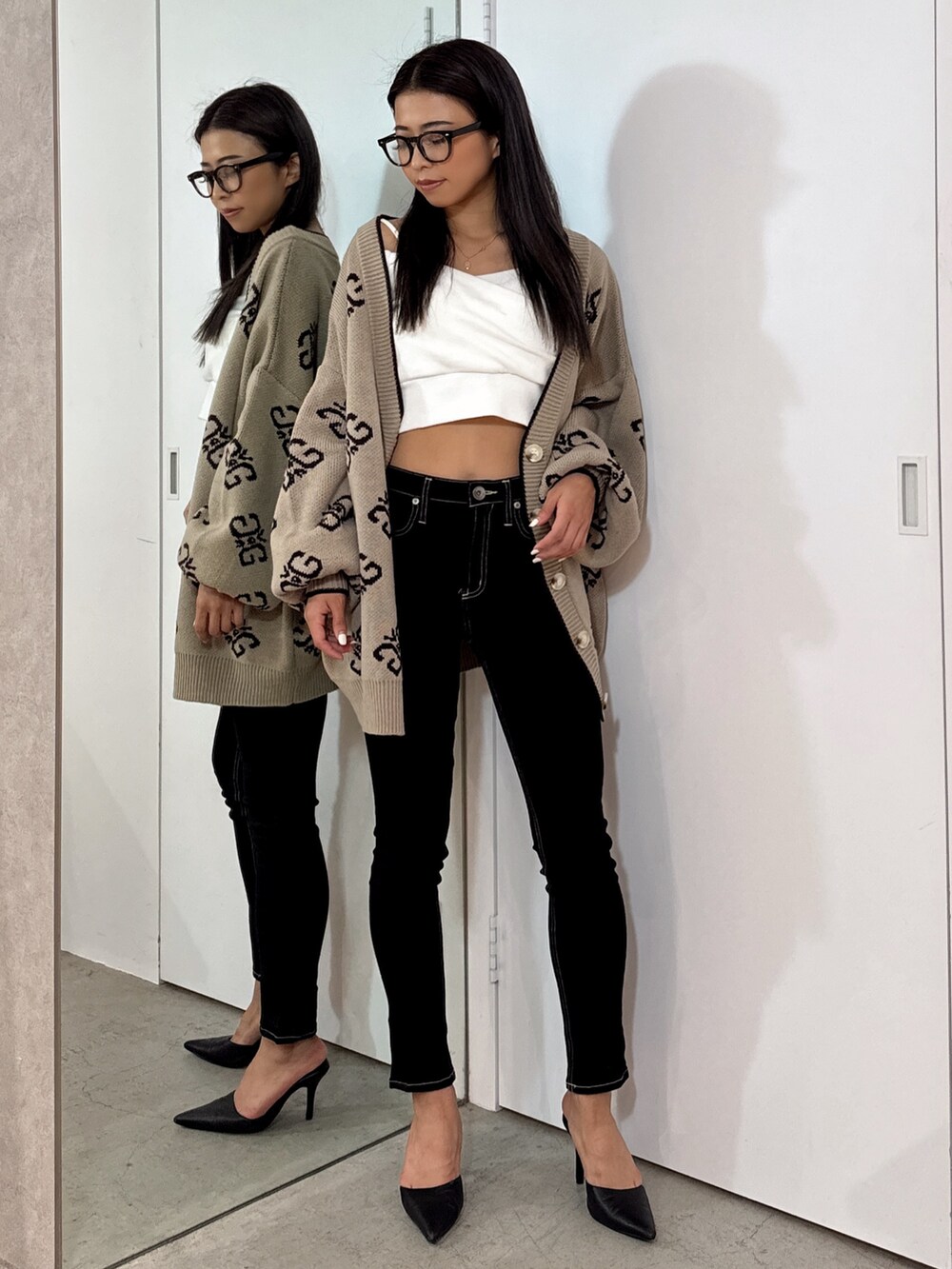 イエロー系のTシャツ/カットソー、ベージュ系のカーディガン/ボレロ、ブラック系のデニムパンツを着用したレディースの秋コーディネートの2枚目の写真