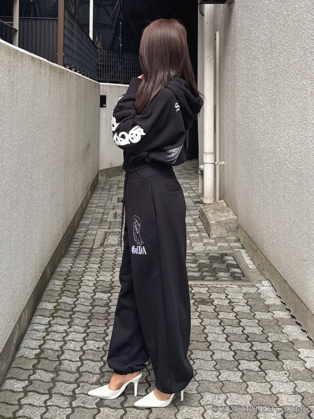 ブラック系のパーカー、ブラック系のその他パンツ、ホワイト系のパンプスを着用したレディースの秋コーディネートの2枚目の写真