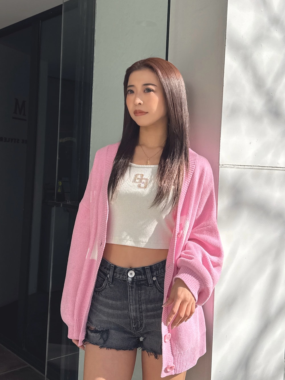 ホワイト系のTシャツ/カットソー、ピンク系のカーディガン/ボレロ、ブラック系のデニムパンツを着用したレディースの春コーディネートの5枚目の写真