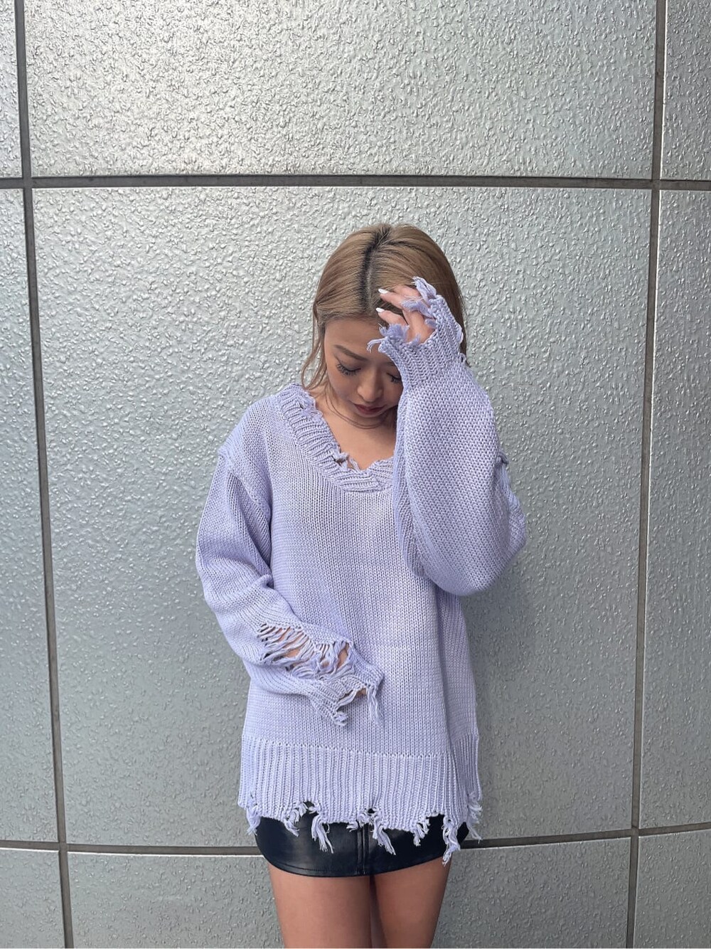 パープル系のニット/セーター、グレー系のハンドバッグ、ブラック系のブーツを着用したレディースの冬コーディネートの5枚目の写真