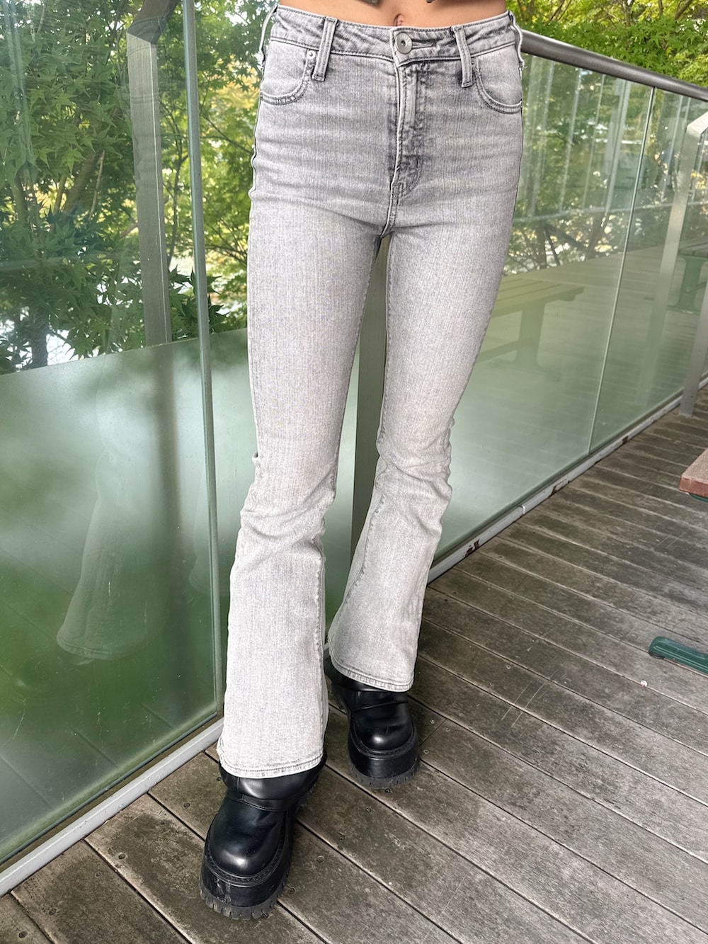 グリーン系のTシャツ/カットソー、グレー系のデニムパンツ、ブラック系のブーツを着用したレディースの秋コーディネートの7枚目の写真