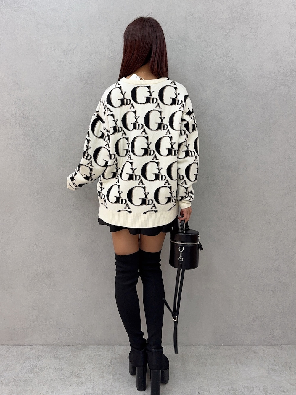 ホワイト系のニット/セーター、ブラック系のスカート、ブラック系のハンドバッグを着用したレディースの冬コーディネートの3枚目の写真