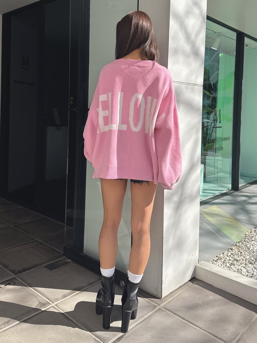 ホワイト系のTシャツ/カットソー、ピンク系のカーディガン/ボレロ、ブラック系のデニムパンツを着用したレディースの春コーディネートの4枚目の写真