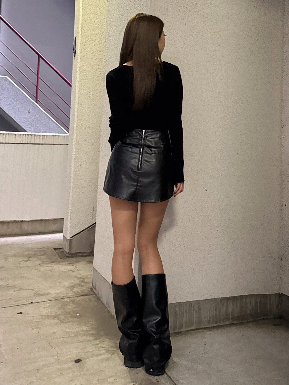 ブラック系のニット/セーター、ブラック系のスカート、ブラック系のブーツを着用したレディースの秋コーディネートの4枚目の写真