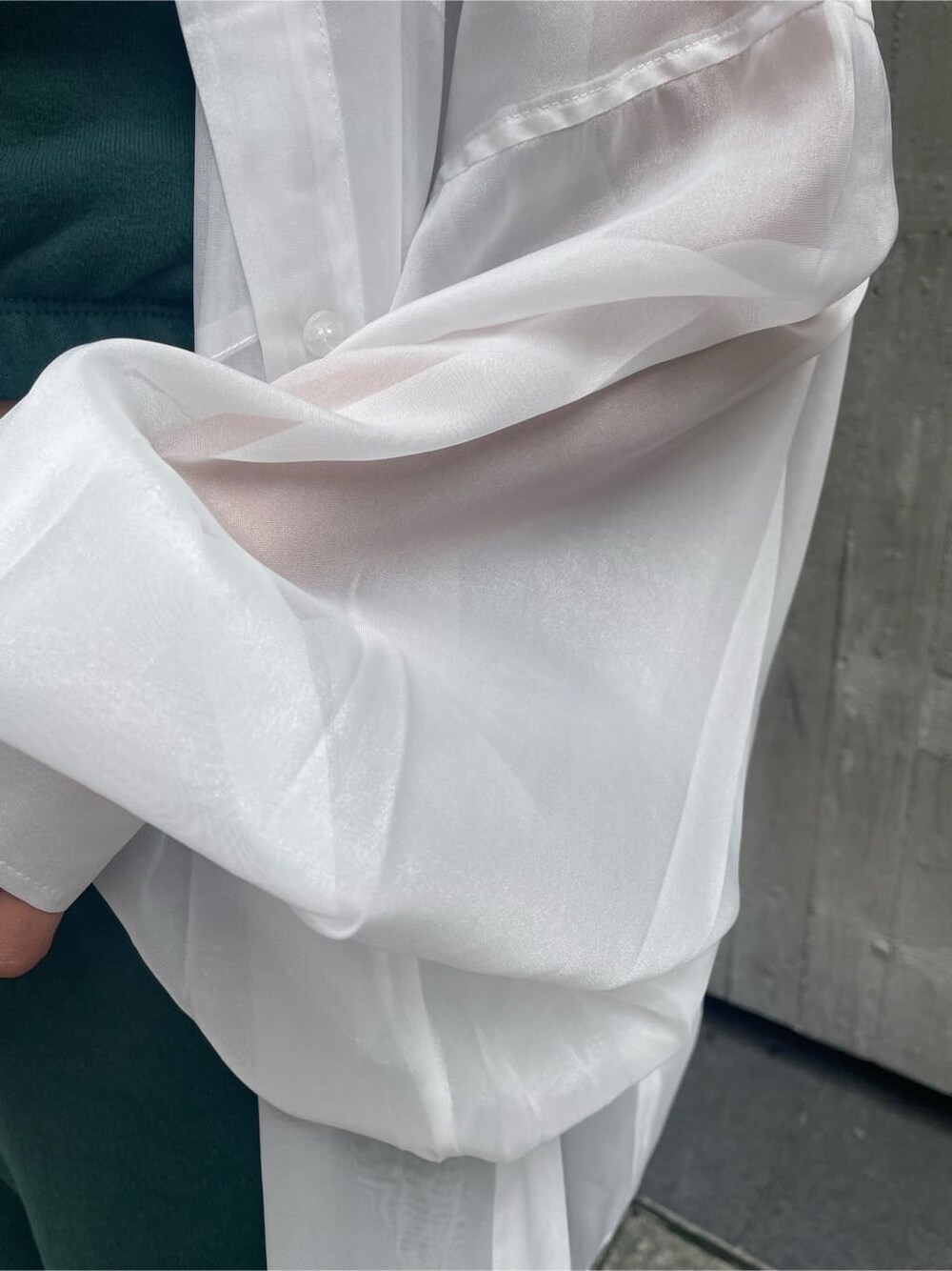 ブラック系のショルダーバッグ、ホワイト系のシャツ/ブラウス、グリーン系のスウェットパンツを着用したレディースの春コーディネートの8枚目の写真