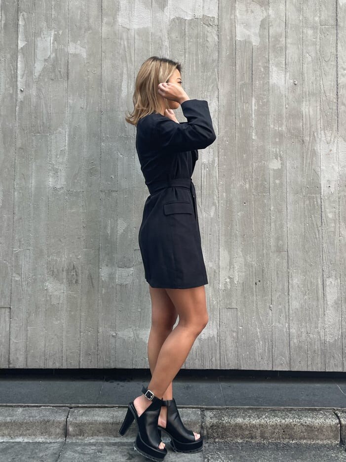 ホワイト系のチューブトップ、ブラック系のパンプス、ブラック系のデニムパンツを着用したレディースの春コーディネートの3枚目の写真