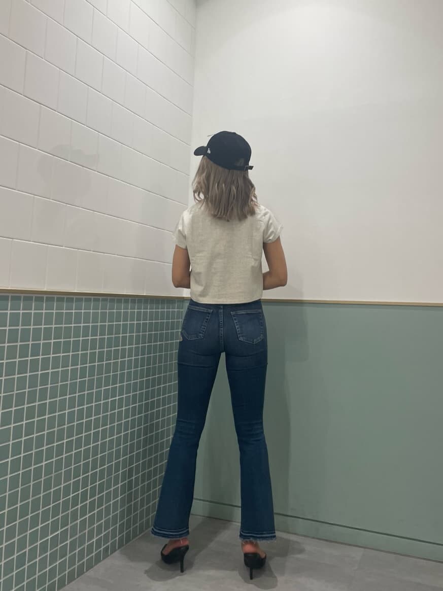 ブラック系のパンプス、グレー系のTシャツ/カットソー、ブルー系のデニムパンツを着用したレディースの春コーディネートの3枚目の写真