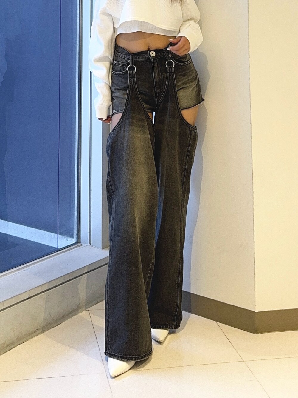 ホワイト系のアンサンブル、ブラック系のデニムパンツ、ホワイト系のパンプスを着用したレディースの秋コーディネートの4枚目の写真