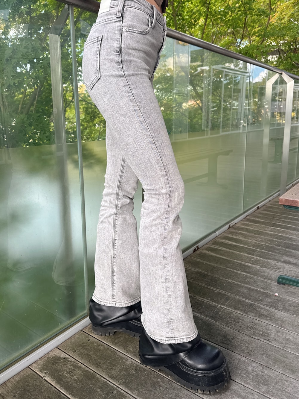 グリーン系のTシャツ/カットソー、グレー系のデニムパンツ、ブラック系のブーツを着用したレディースの秋コーディネートの8枚目の写真