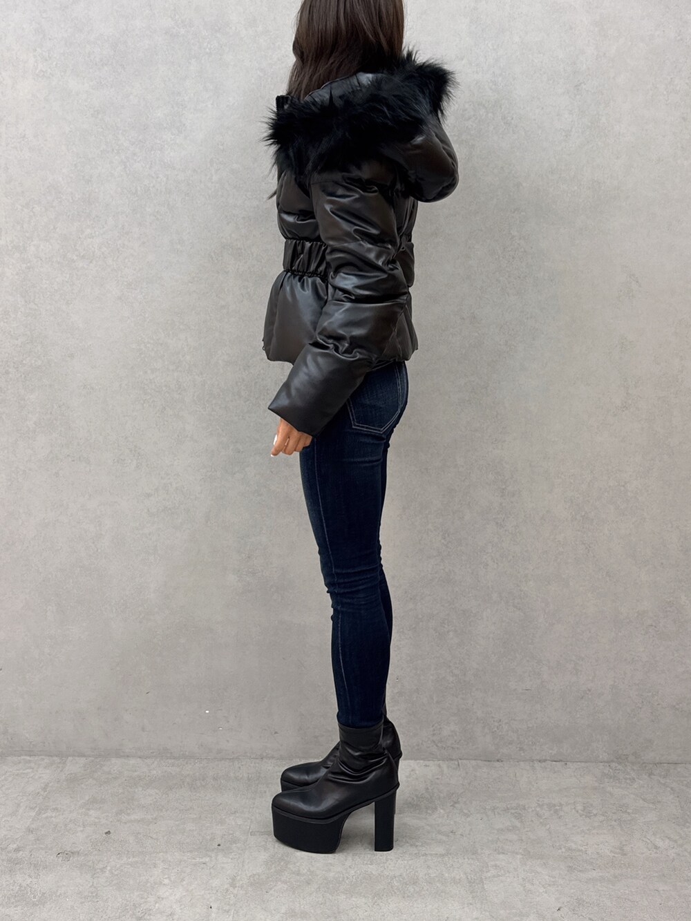 ホワイト系のニット/セーター、ブルー系のデニムパンツ、ブラック系のブーツを着用したレディースの秋コーディネートの2枚目の写真