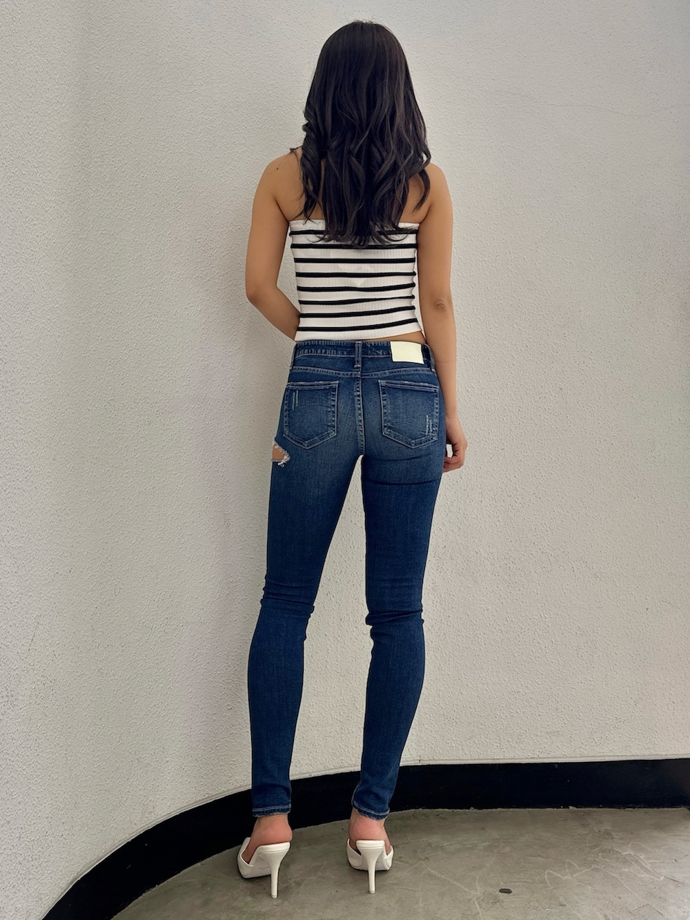 その他のチューブトップ、ブルー系のデニムパンツ、ホワイト系のパンプスを着用したレディースの春コーディネートの3枚目の写真