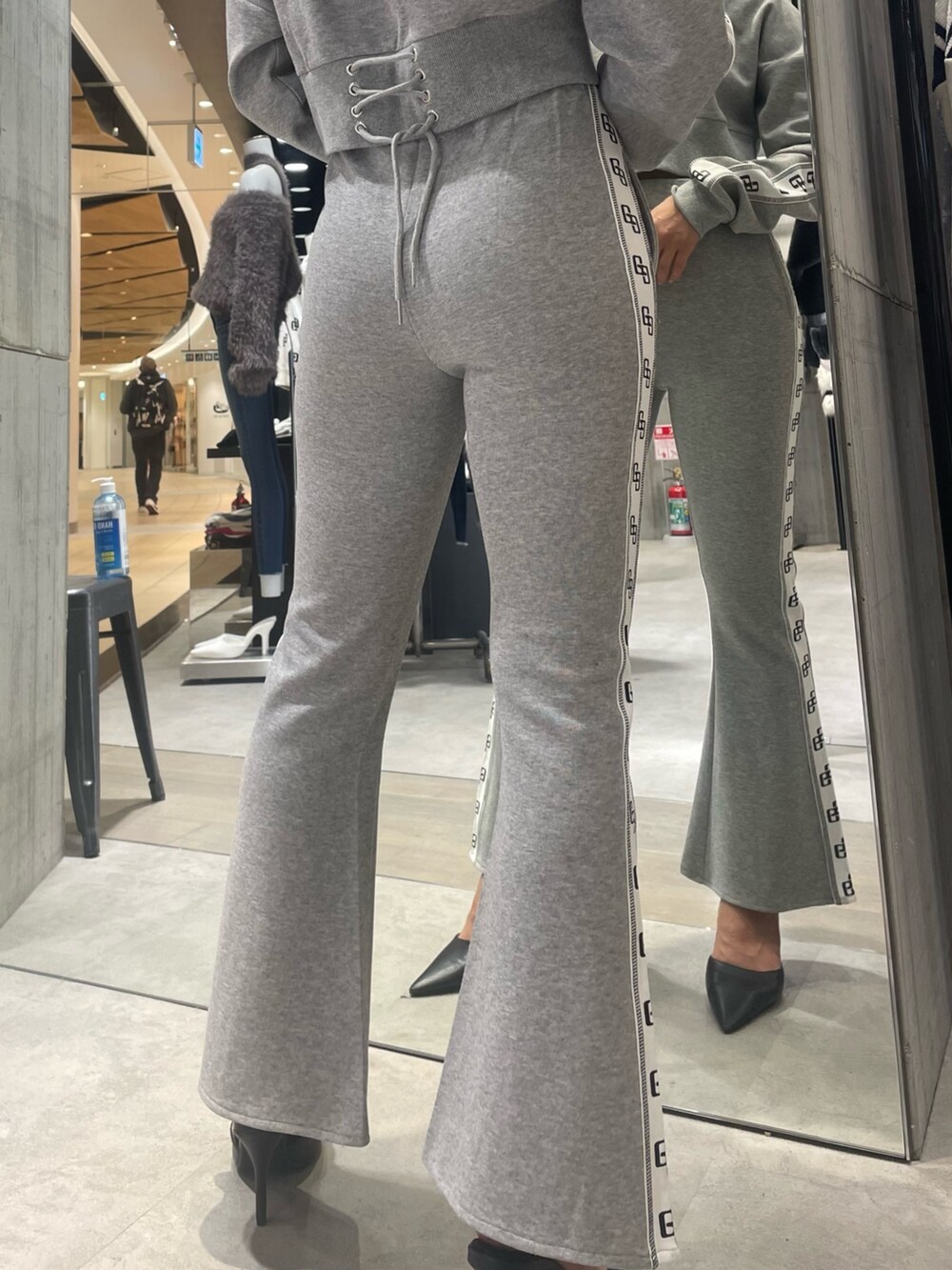 グレー系のその他パンツ、グレー系のパーカー、ブラック系のパンプスを着用したレディースの冬コーディネートの6枚目の写真