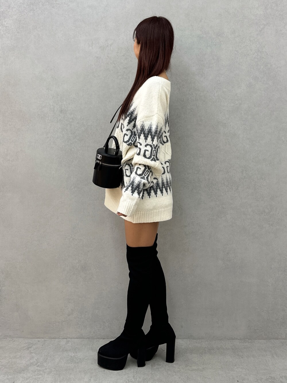 ホワイト系のニット/セーター、ブラック系のハンドバッグ、ブラック系のブーツを着用したレディースの冬コーディネートの3枚目の写真