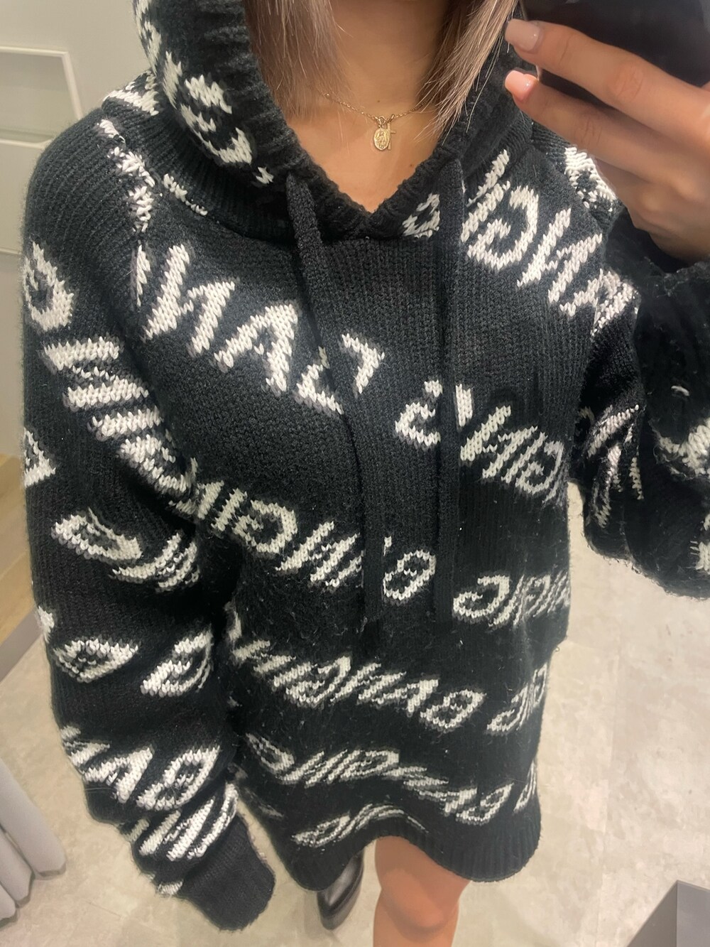 ブラック系のニット/セーター、ブラック系のブーツを着用したレディースの冬コーディネートの6枚目の写真