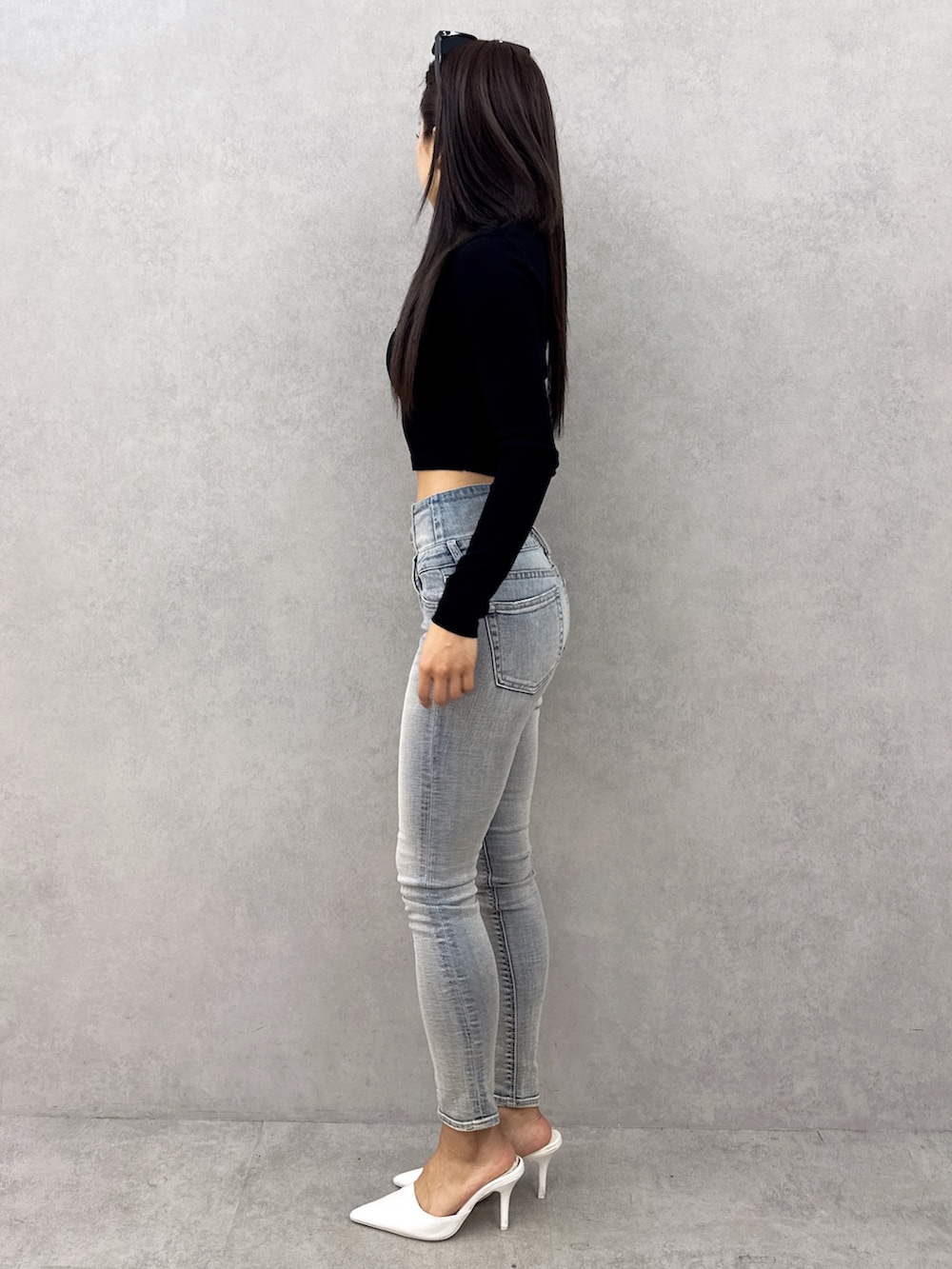 ブラック系のニット/セーター、ブルー系のデニムパンツ、ホワイト系のパンプスを着用したレディースの春コーディネートの3枚目の写真