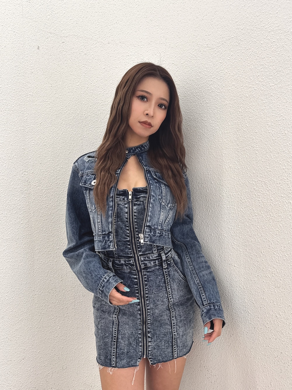 ブルー系のデニムジャケット、ブルー系のワンピース、ホワイト系のブーツを着用したレディースの春コーディネートの5枚目の写真