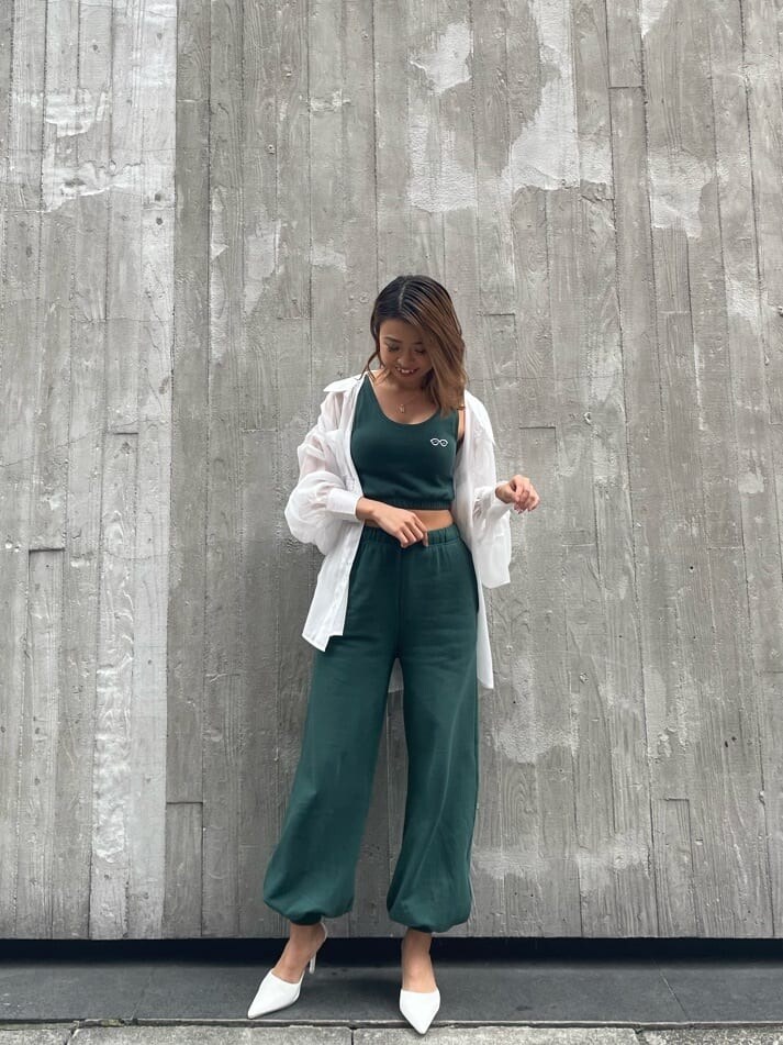 ブラック系のショルダーバッグ、ホワイト系のシャツ/ブラウス、グリーン系のスウェットパンツを着用したレディースの春コーディネートの2枚目の写真