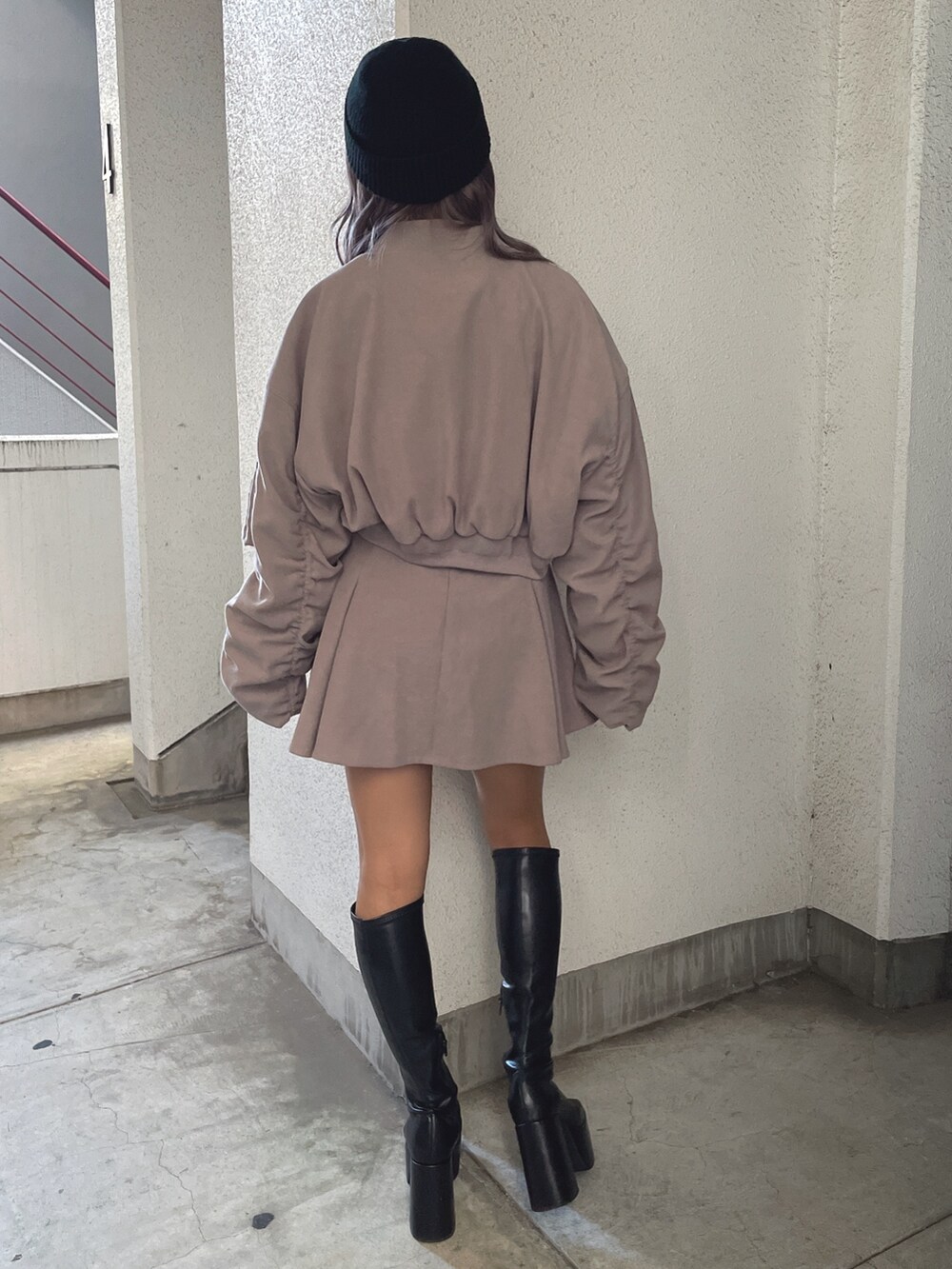 ベージュ系のブルゾン、ベージュ系のスカート、ホワイト系のTシャツ/カットソーを着用したレディースの冬コーディネートの4枚目の写真