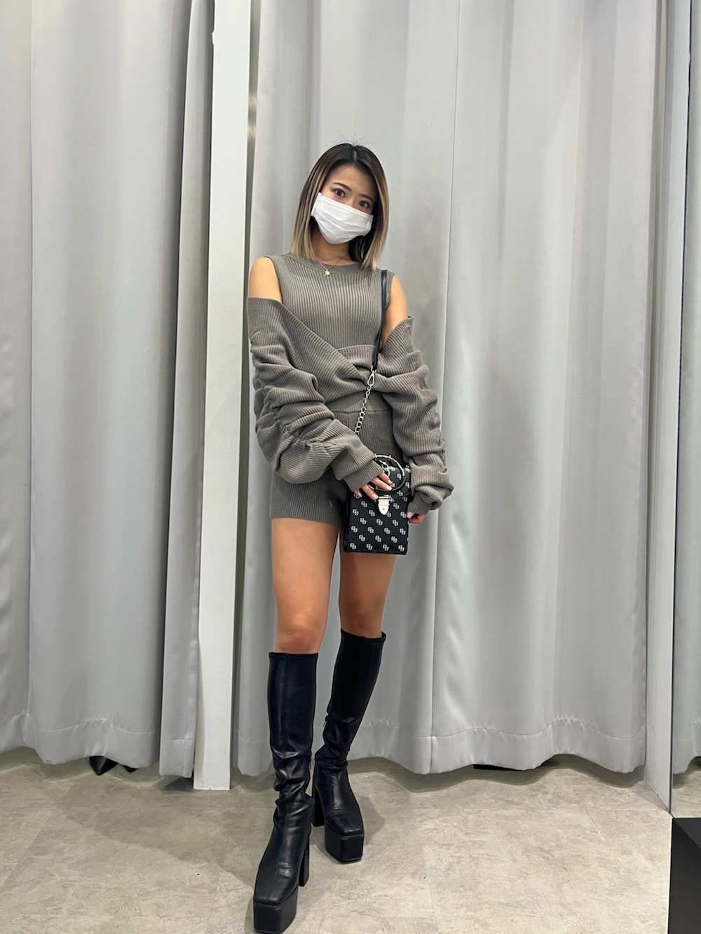 ベージュ系のサロペット/オーバーオール、ブラック系のショルダーバッグ、ブラック系のブーツを着用したレディースの冬コーディネートの2枚目の写真
