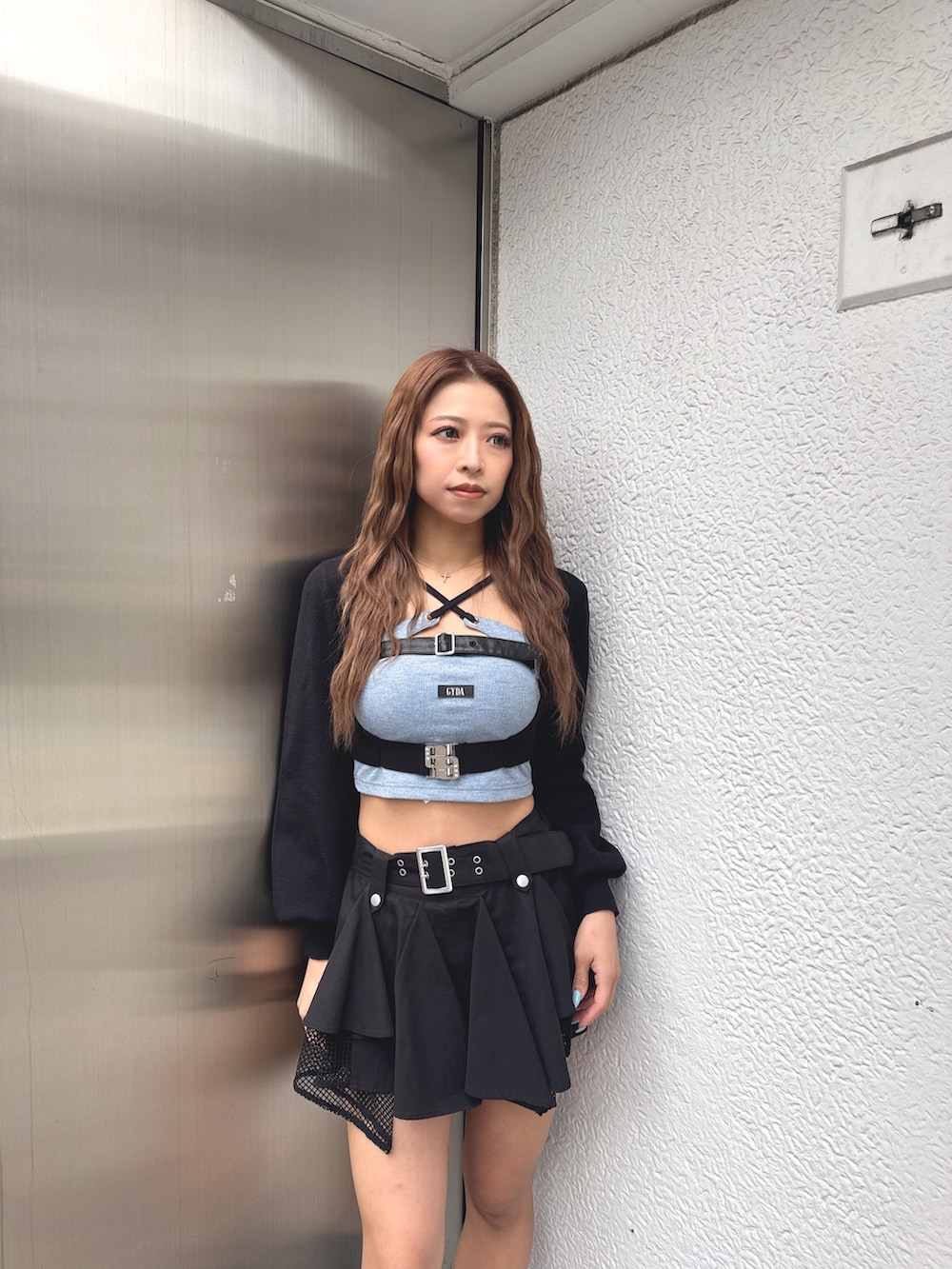 ブルー系のTシャツ/カットソー、ブラック系のカーディガン/ボレロ、ブラック系のスカートを着用したレディースの春コーディネートの4枚目の写真