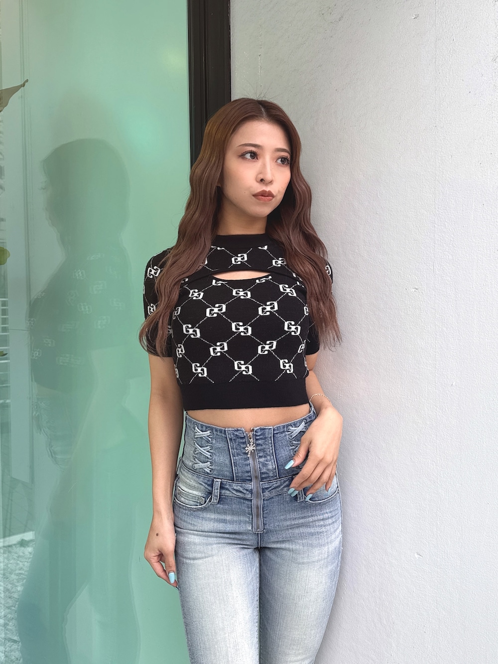 ブラック系のニット/セーター、ブルー系のデニムパンツ、ブラック系のパンプスを着用したレディースの春コーディネートの5枚目の写真