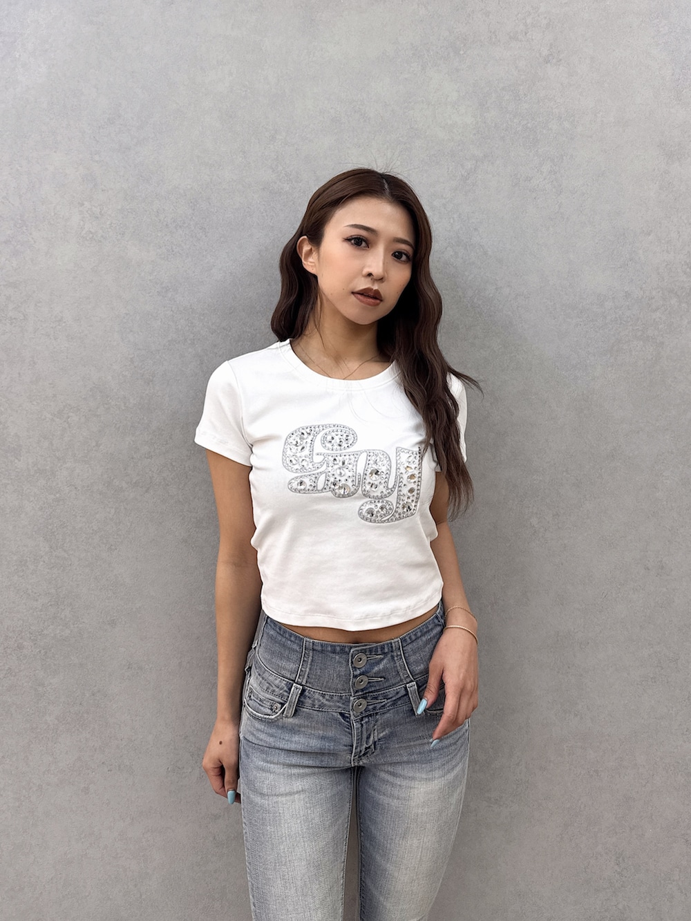 ホワイト系のTシャツ/カットソー、ブルー系のデニムパンツ、ブラック系のパンプスを着用したレディースの春コーディネートの5枚目の写真