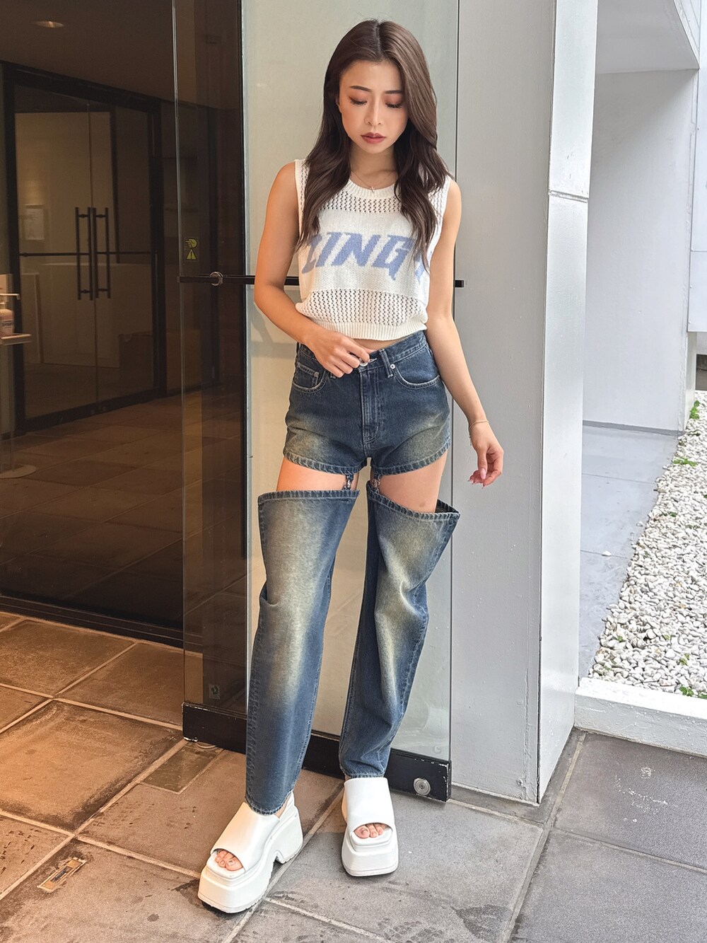 ホワイト系のタンクトップ、ブルー系のデニムパンツ、ホワイト系のサンダルを着用したレディースの春コーディネートの2枚目の写真