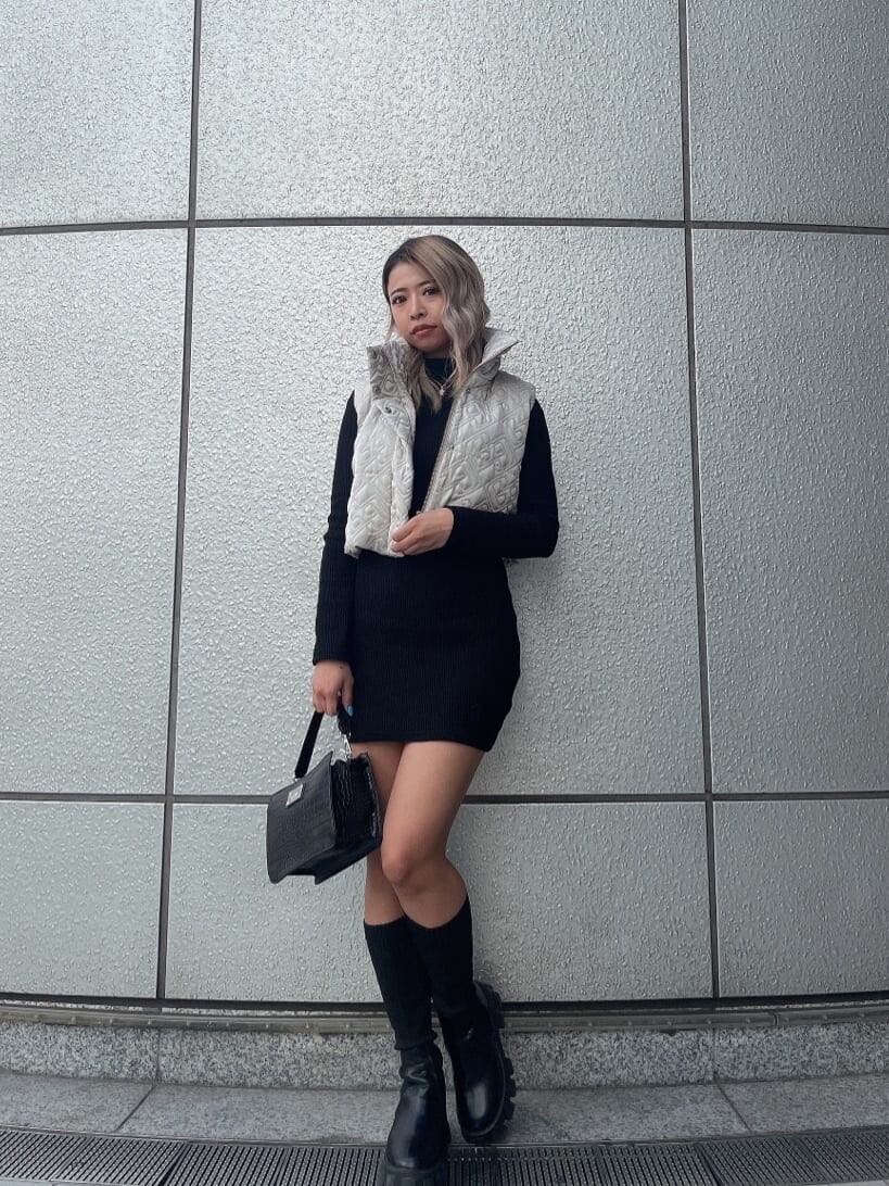 ブラック系のハンドバッグ、ブラック系のワンピース、ブラック系のブーツを着用したレディースの秋コーディネートの2枚目の写真