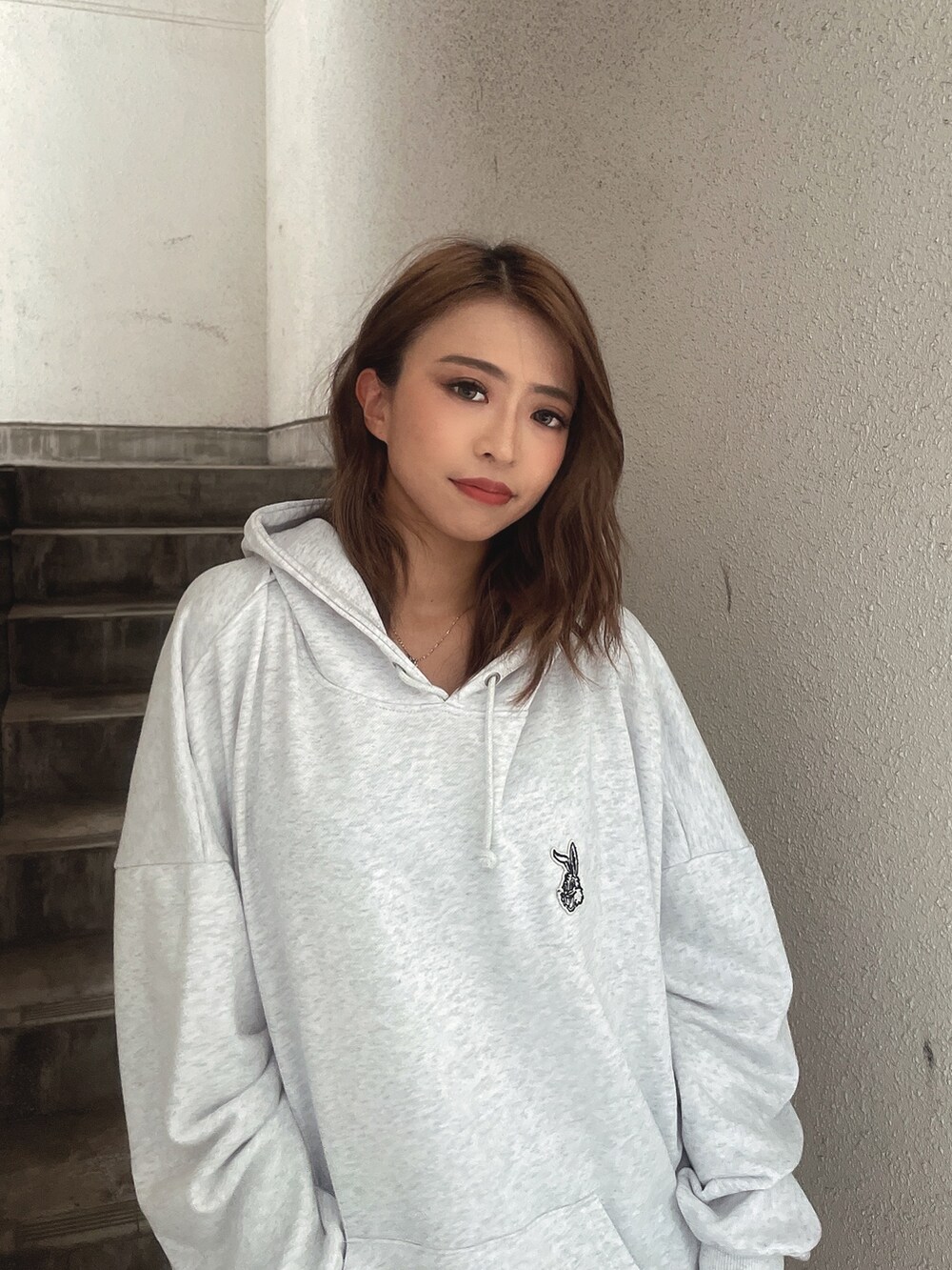 グレー系のスウェット、ブルー系のデニムスカート、ブラック系のブーツを着用したレディースの秋コーディネートの5枚目の写真