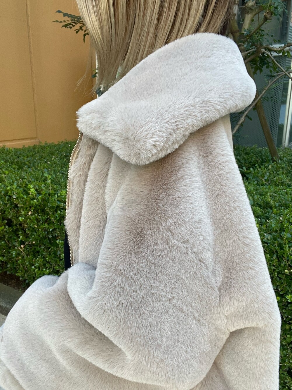 ベージュ系のブルゾン、ブラック系のワンピース、ブラック系のブーツを着用したレディースの冬コーディネートの9枚目の写真