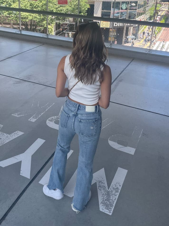 ブルー系のデニムパンツ、ホワイト系のタンクトップを着用したレディースの夏コーディネートの2枚目の写真