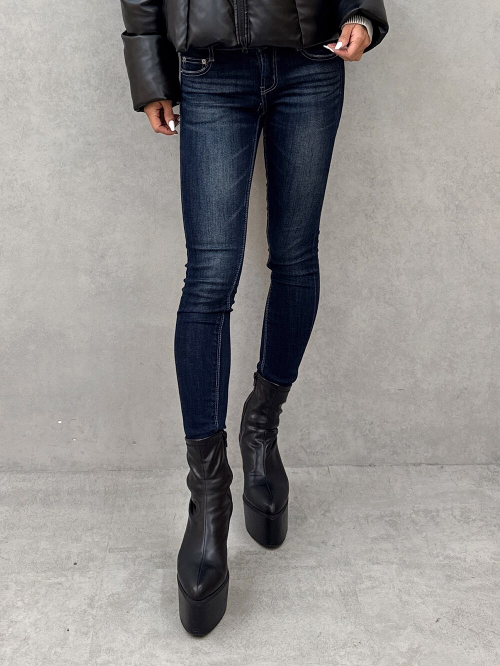 ホワイト系のニット/セーター、ブルー系のデニムパンツ、ブラック系のブーツを着用したレディースの秋コーディネートの6枚目の写真