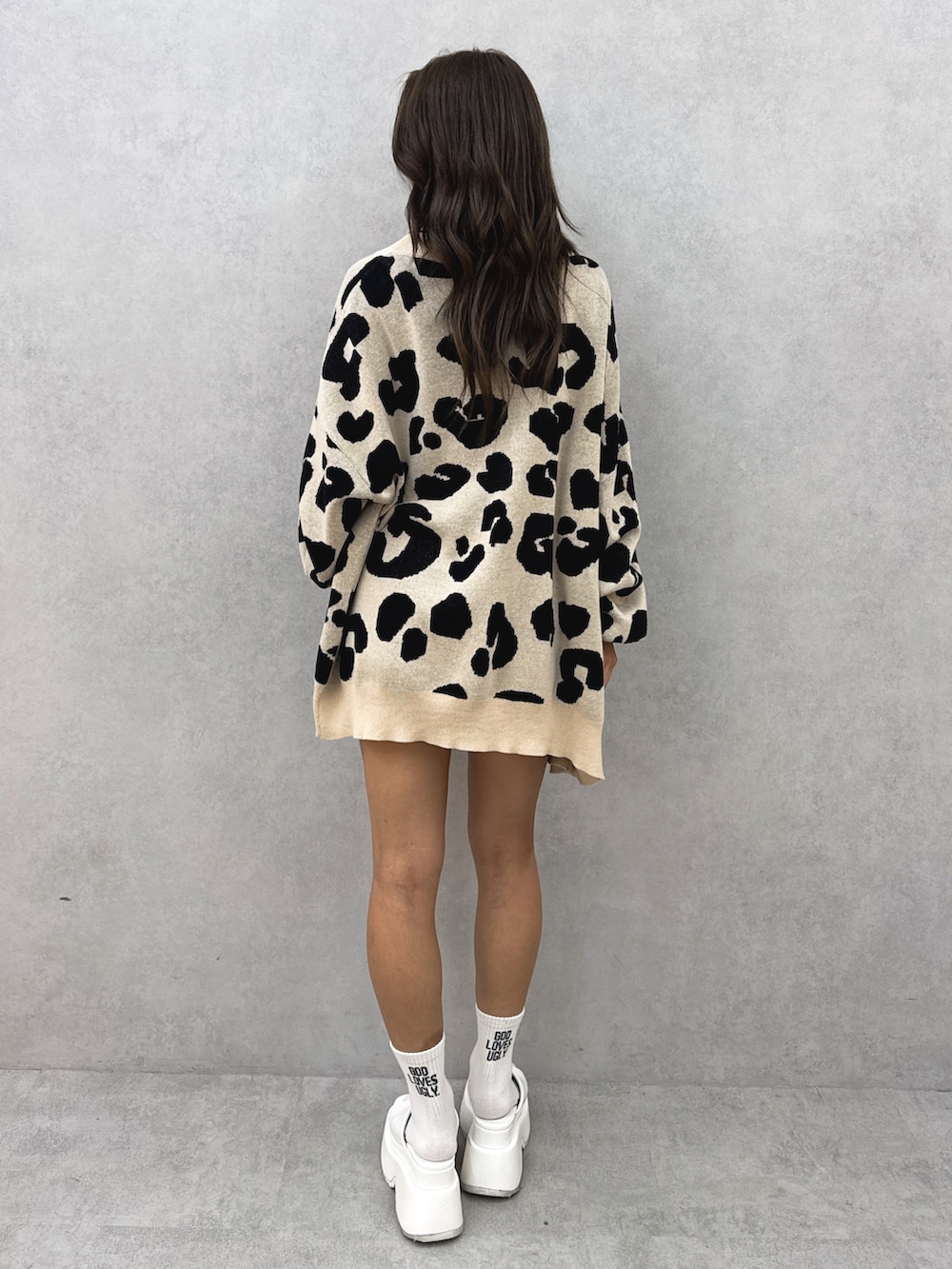 ホワイト系のチューブトップ、ベージュ系のカーディガン/ボレロ、ブルー系のデニムパンツを着用したレディースの夏コーディネートの4枚目の写真