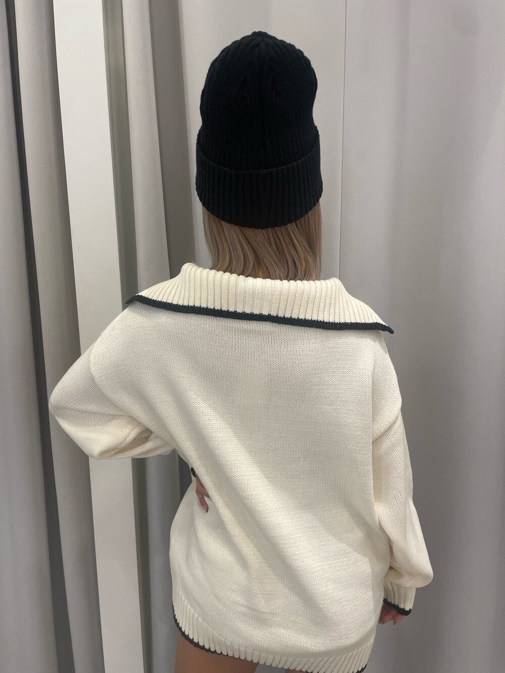 ホワイト系のニット/セーター、ブラック系のスカート、ブラック系のブーツを着用したレディースの冬コーディネートの7枚目の写真