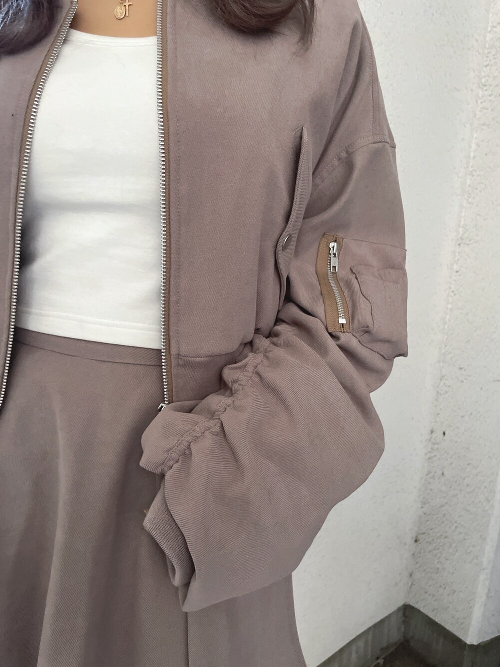 ベージュ系のブルゾン、ベージュ系のスカート、ホワイト系のTシャツ/カットソーを着用したレディースの冬コーディネートの9枚目の写真