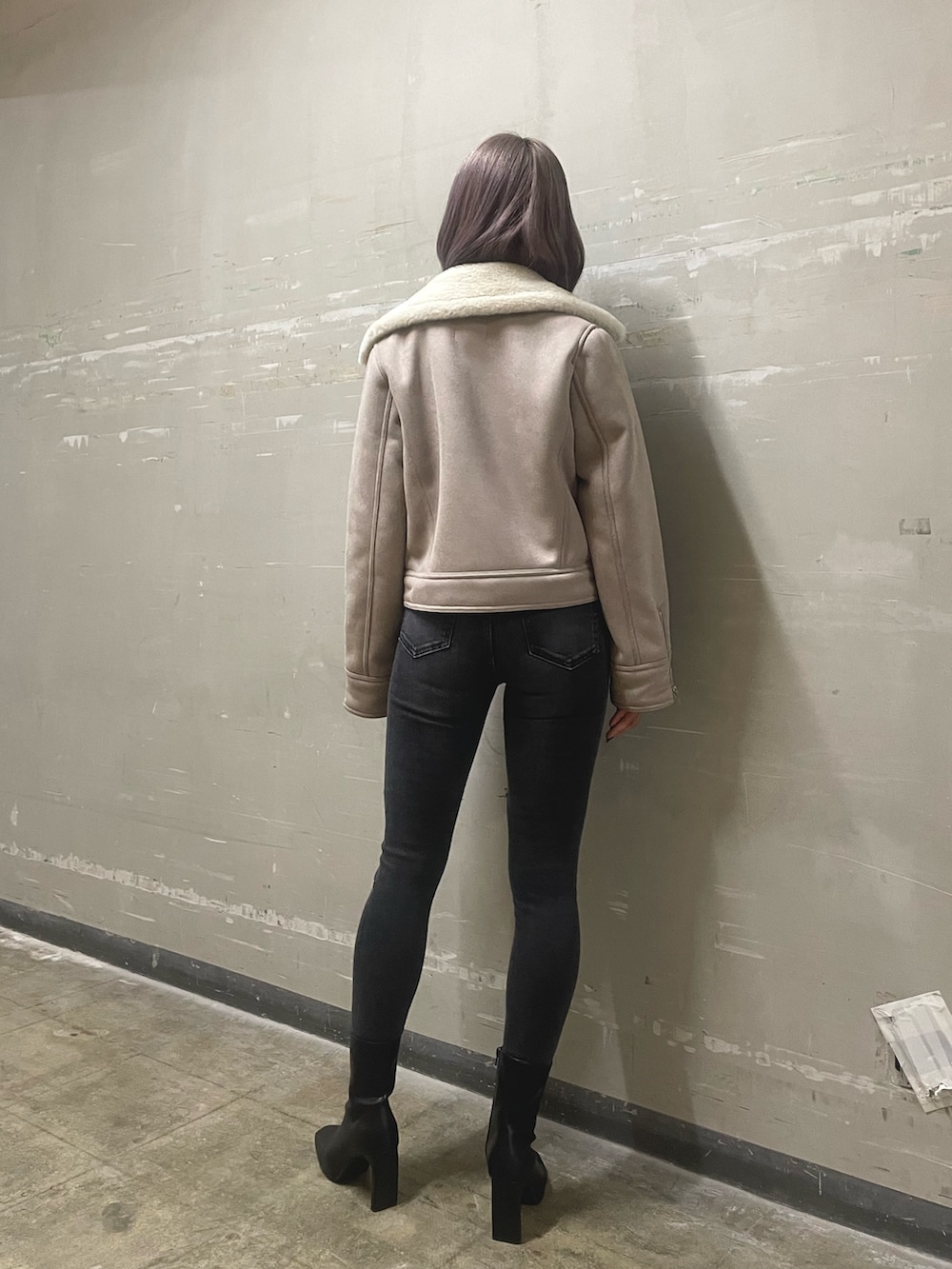 ブラック系のデニムパンツ、ブラック系のブーツ、ブラック系のニット/セーターを着用したレディースの秋コーディネートの3枚目の写真