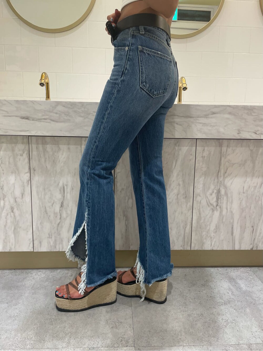 ブルー系のデニムパンツ、ホワイト系のキャミソール、ブラック系のサンダルを着用したレディースの夏コーディネートの6枚目の写真