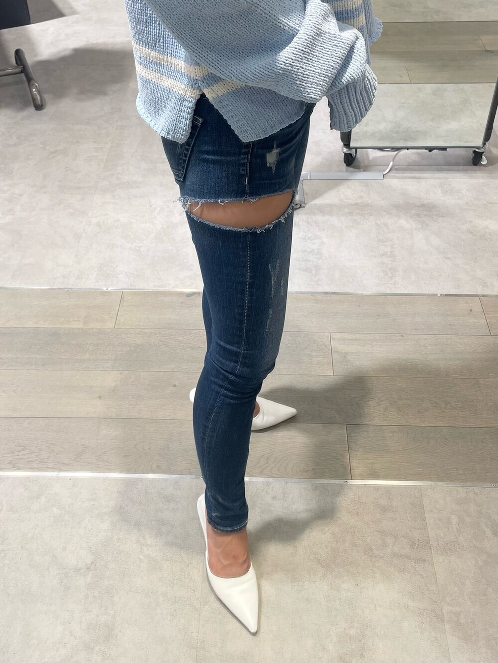 ブルー系のニット/セーター、ブルー系のデニムパンツ、ホワイト系のパンプスを着用したレディースの冬コーディネートの7枚目の写真