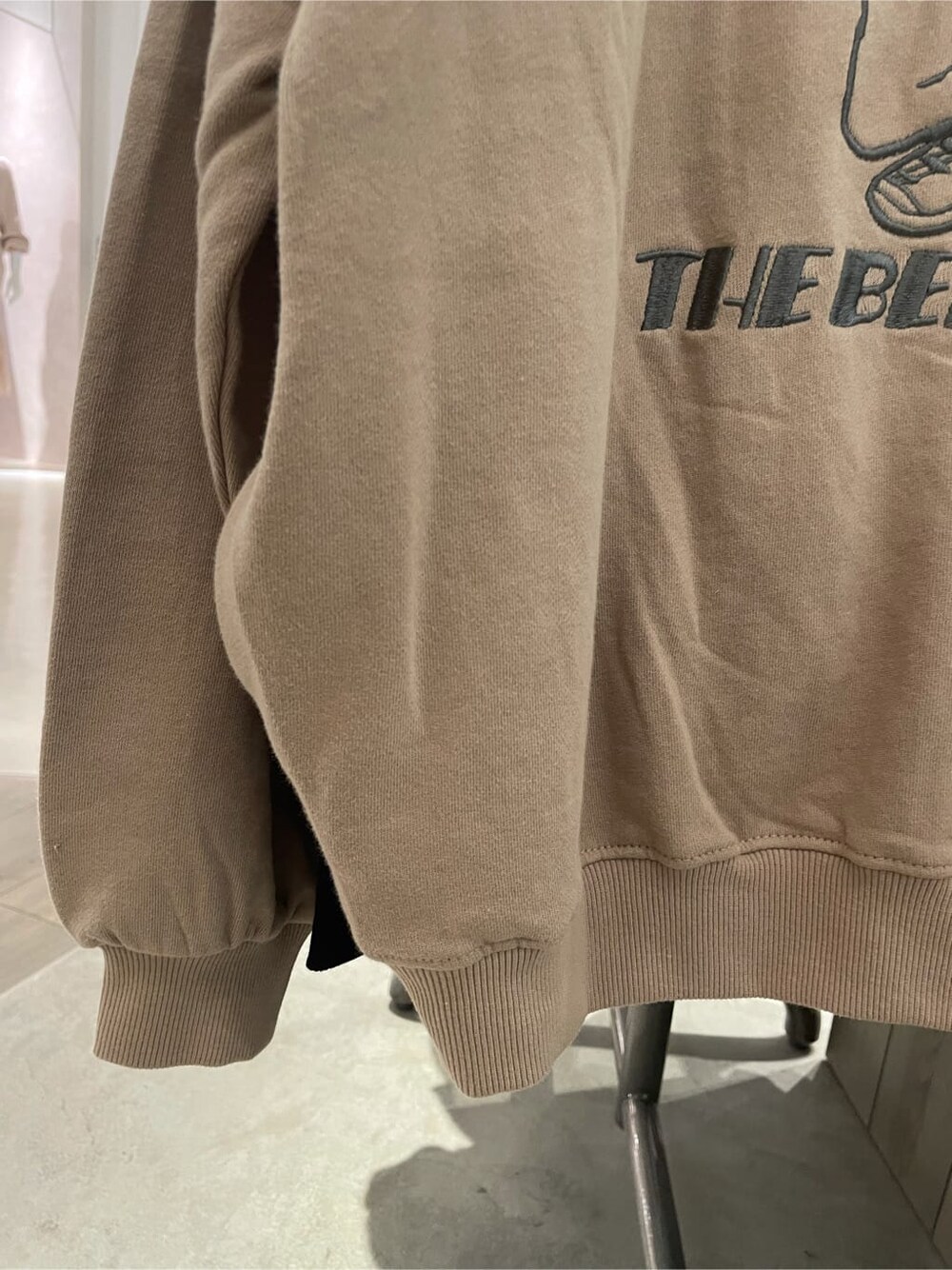 ブラック系のブーツ、ベージュ系のパーカー、ゴールド系のネックレスを着用したレディースの秋コーディネートの5枚目の写真