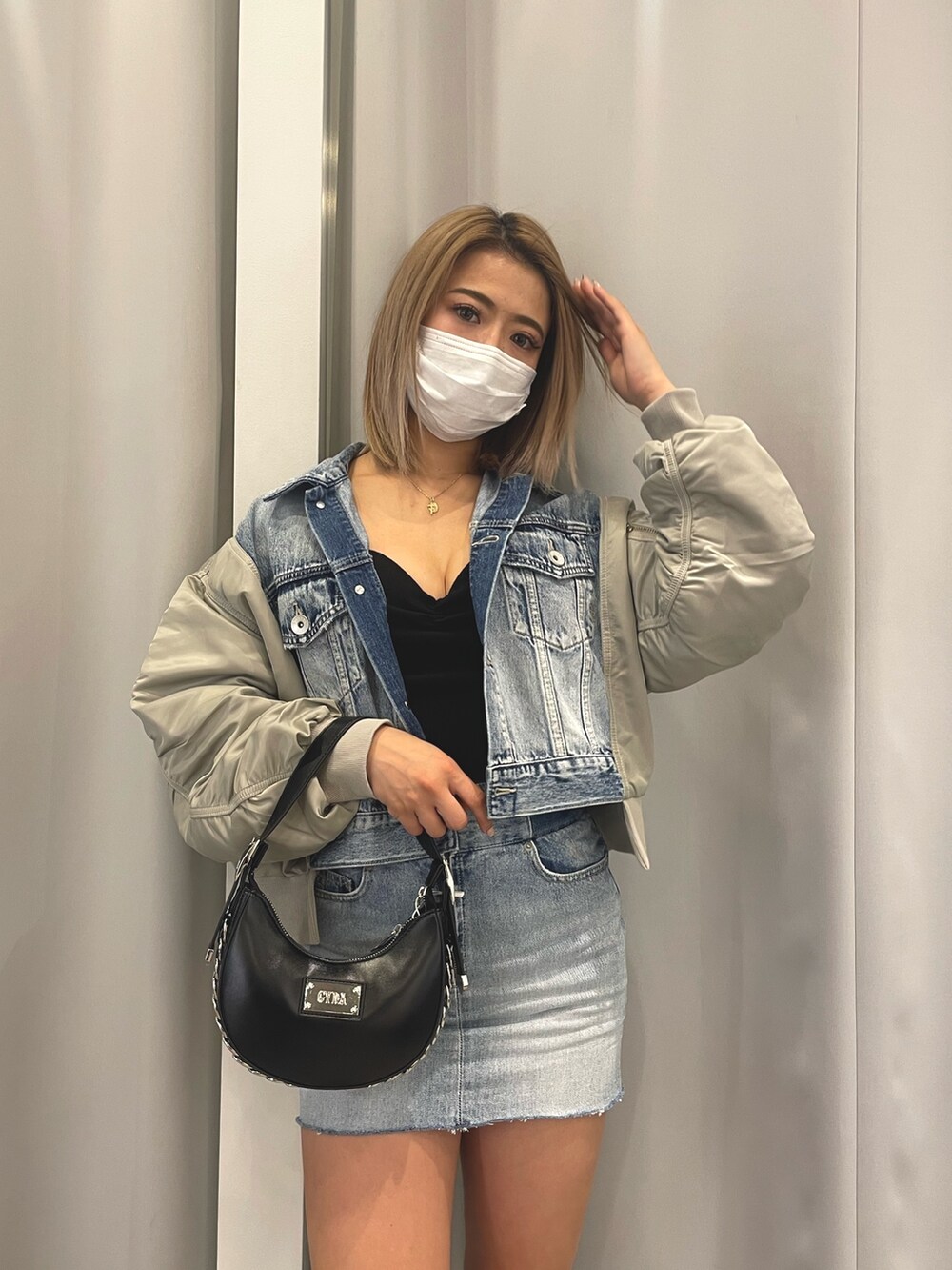 ブルー系のデニムジャケット、ブルー系のデニムスカート、ブラック系のチューブトップを着用したレディースの冬コーディネートの3枚目の写真