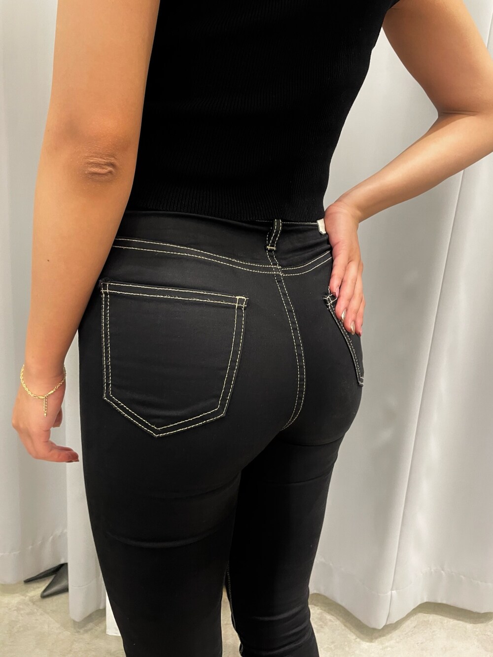 ブラック系のニット/セーター、ブラック系のデニムパンツ、ホワイト系のパンプスを着用したレディースの夏コーディネートの7枚目の写真
